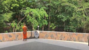 Monk standing alone on building at Wat Nong Pah Pong in Warin Chamrap, Ubon Ratchathani in Thailand's northeast or "Isaan" region.
