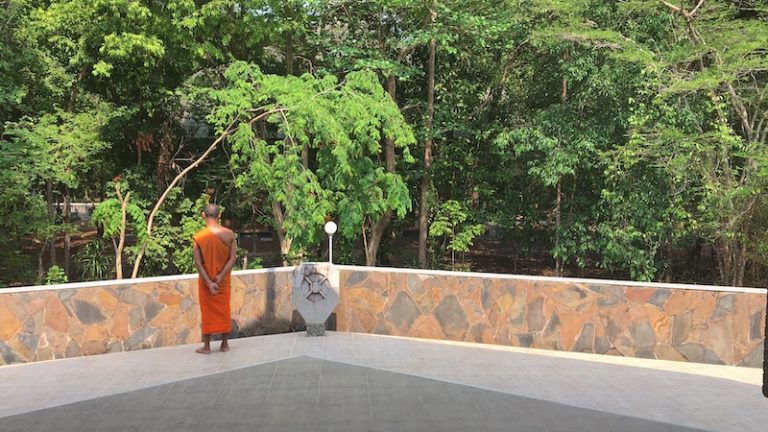 Monk standing alone on building at Wat Nong Pah Pong in Warin Chamrap, Ubon Ratchathani in Thailand's northeast or "Isaan" region.